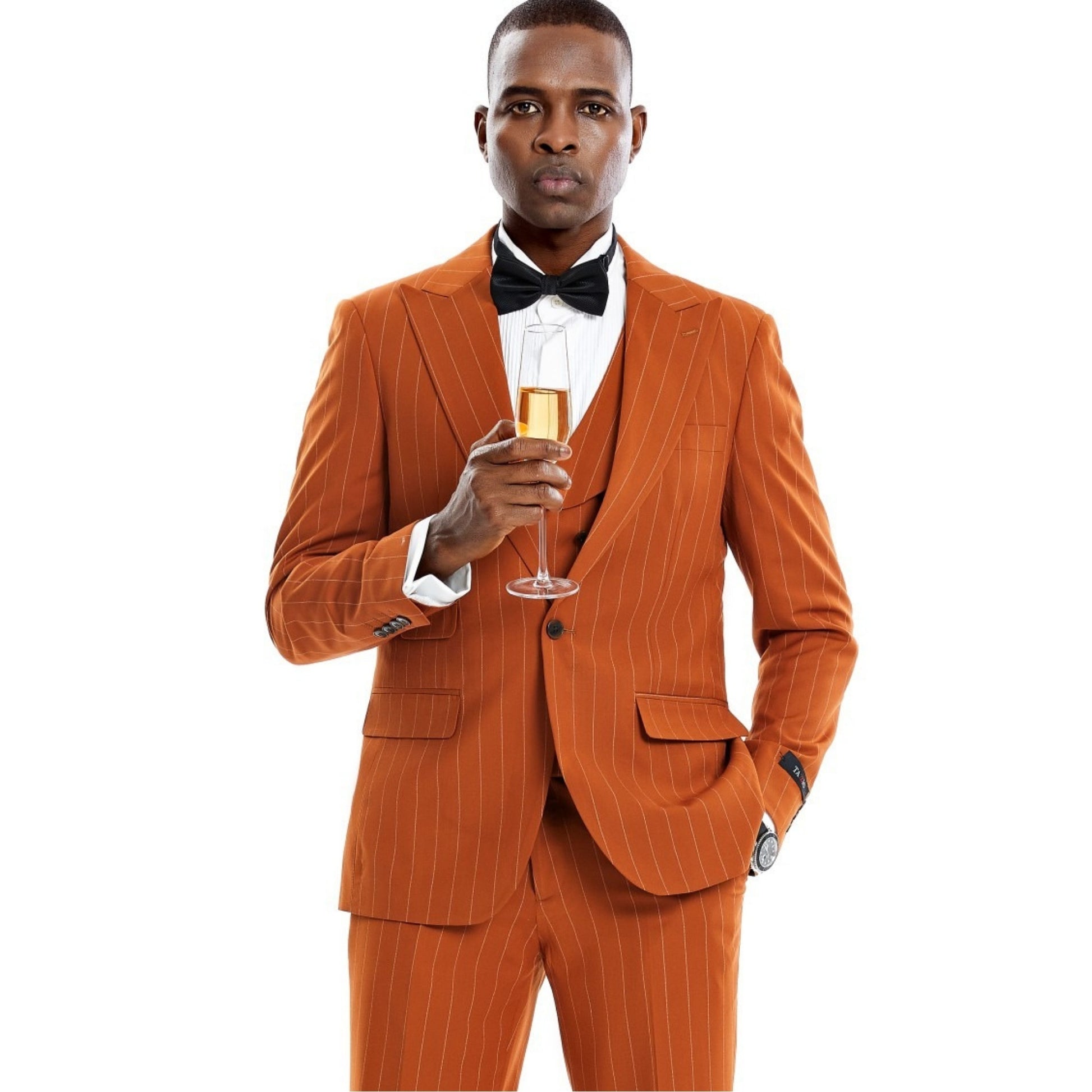 Elegant man in a burnt orange pinstripe three-piece suit, holding a champagne glass."