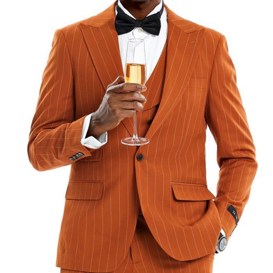 Elegant man in a burnt orange pinstripe three-piece suit, holding a champagne glass.