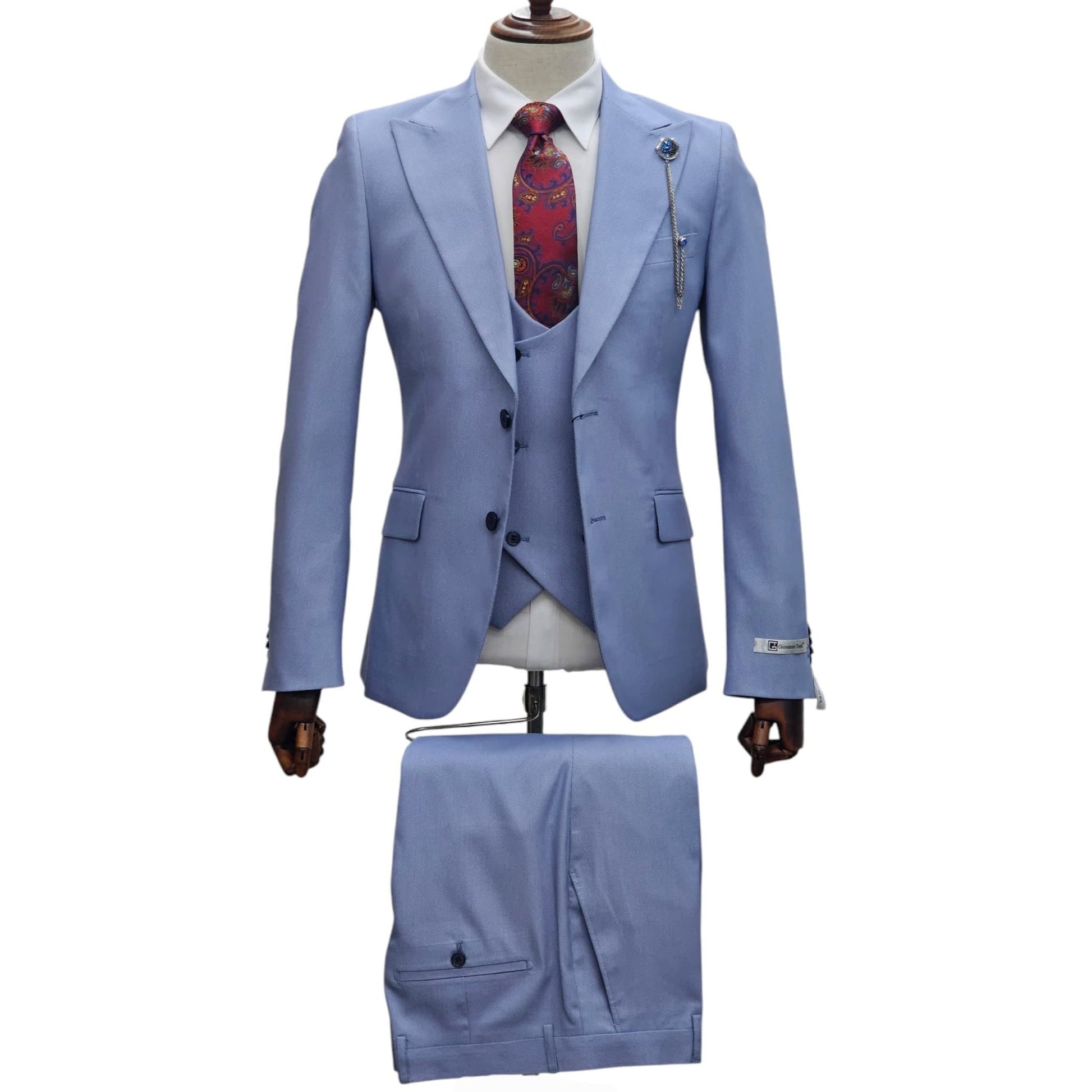 Full view of Light Blue Slim Fit Suit with matching vest and trousers, styled with a patterned tie and lapel pin for a refined look.