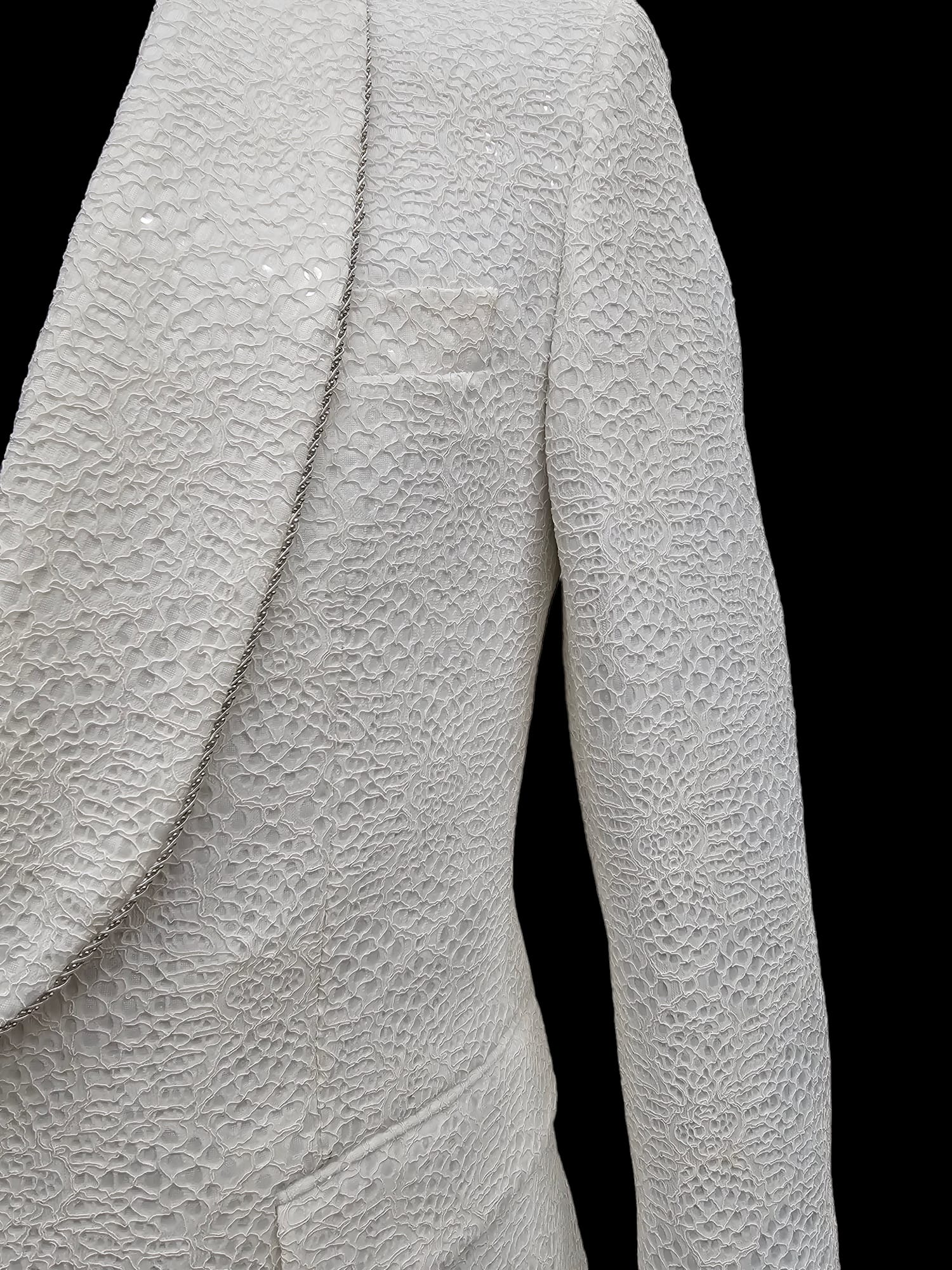 KCT Menswear's white textured tuxedo suit with an intricate pattern, perfect for high-class events.