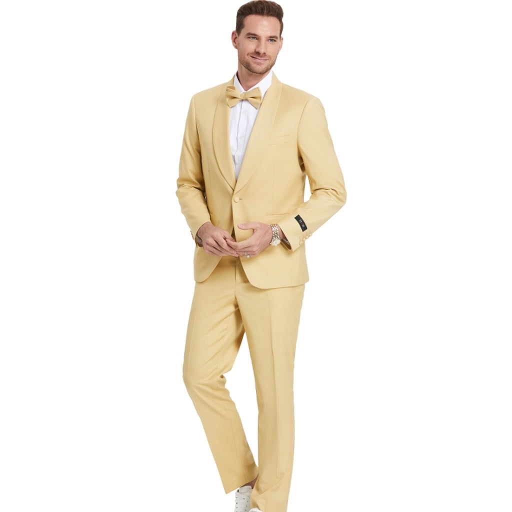A model wearing a Light Gold  prom tuxedo from KCT Menswear, featuring a slim-fit design with a single-button closure and shawl lapel. The tuxedo comes with a matching bowtie for a coordinated and polished look. Perfect for proms and other formal events